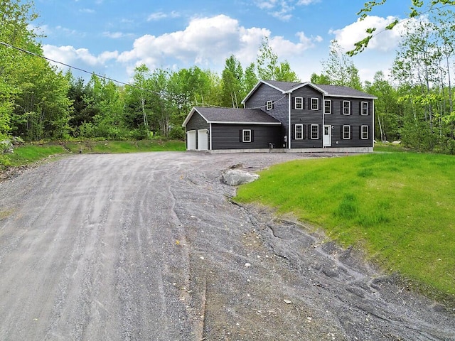 65 May Way, Sidney, ME 04330 - colonial-style house with driveway, an attached garage, and a front yard