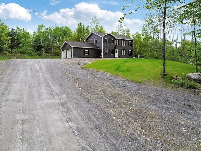65 May Way, Sidney, ME 04330 - colonial home featuring dirt driveway, an attached garage, and a front lawn