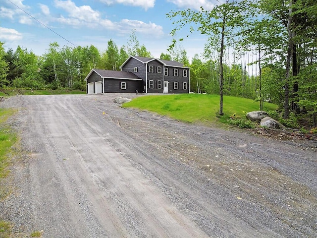65 May Way, Sidney, ME 04330 - view of front of house featuring dirt driveway, a garage, and a front lawn