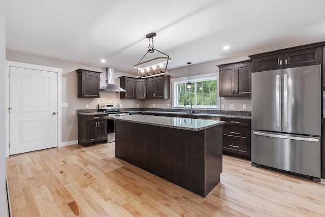65 May Way, Sidney, ME 04330 - kitchen with appliances with stainless steel finishes, wall chimney exhaust hood, dark brown cabinets, a center island, and light wood-style flooring