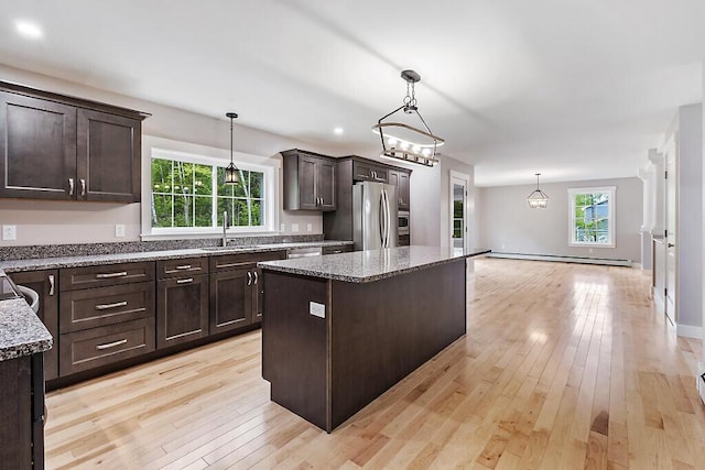 65 May Way, Sidney, ME 04330 - kitchen featuring stainless steel appliances, dark brown cabinetry, a sink, light wood finished floors, and a kitchen island