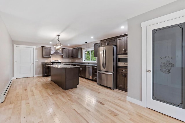 65 May Way, Sidney, ME 04330 - kitchen with appliances with stainless steel finishes, exhaust hood, a baseboard heating unit, dark brown cabinets, and a kitchen island