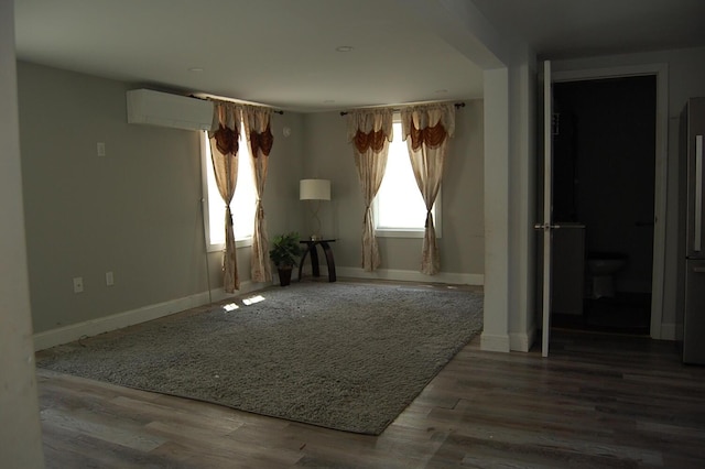 30 Westland Ave, Biddeford, ME 04005 - empty room with a wall unit AC, baseboards, and wood finished floors