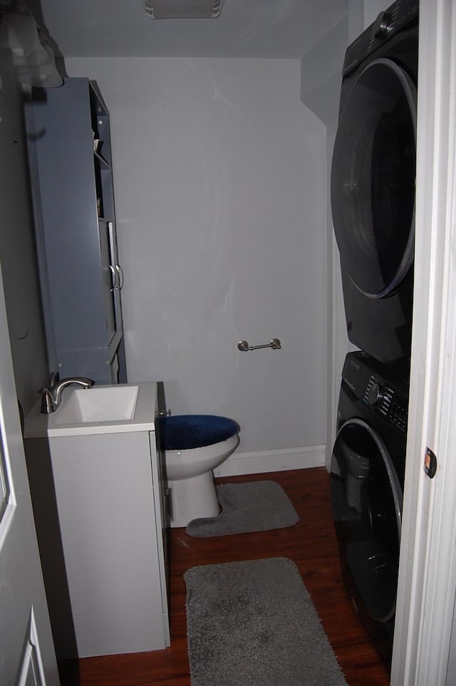30 Westland Ave, Biddeford, ME 04005 - bathroom featuring stacked washer and clothes dryer, toilet, vanity, wood finished floors, and baseboards