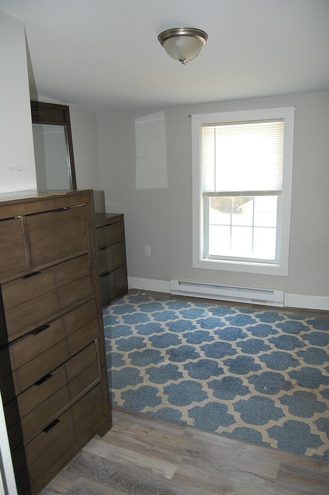 30 Westland Ave, Biddeford, ME 04005 - unfurnished bedroom featuring a baseboard heating unit, wood finished floors, and baseboards