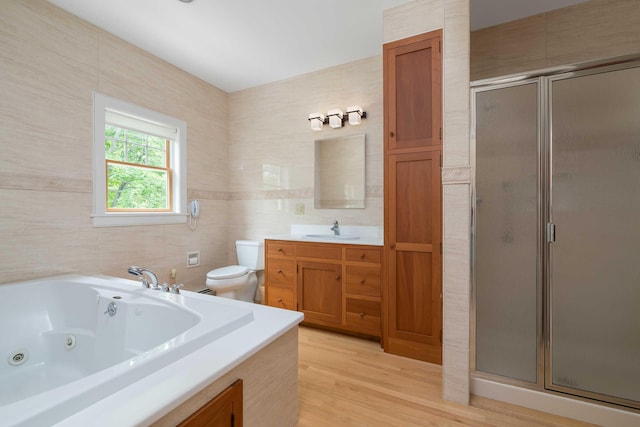 22 Saints Pl, Wells, ME 04090 - full bath featuring a shower stall, vanity, a jetted tub, wood finished floors, and tile walls
