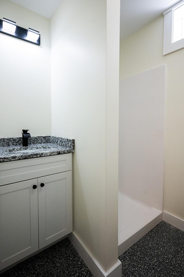 74 Hebron Rd, Paris, ME 04281 - full bathroom with baseboards, vanity, and speckle patterned floor