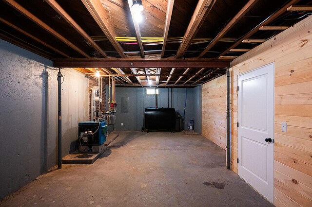 74 Hebron Rd, Paris, ME 04281 - unfinished below grade area with oil tank, wood walls, and a heating unit