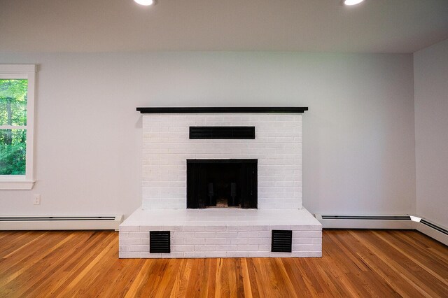 74 Hebron Rd, Paris, ME 04281 - detailed view of a baseboard radiator, wood finished floors, recessed lighting, and a brick fireplace