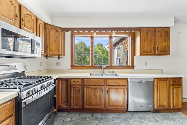 117 Taylor Woods Rd, Belgrade, ME 04917 - kitchen featuring appliances with stainless steel finishes, a sink, brown cabinetry, and light countertops