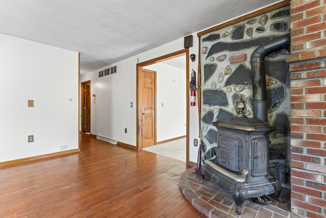 117 Taylor Woods Rd, Belgrade, ME 04917 - living area with a wood stove, hardwood / wood-style floors, and baseboards