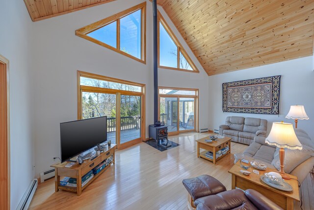 438 Oak Point Rd, Trenton, ME 04605 - living area featuring a wood stove, high vaulted ceiling, a baseboard radiator, wooden ceiling with exposed beams, and light wood-type flooring