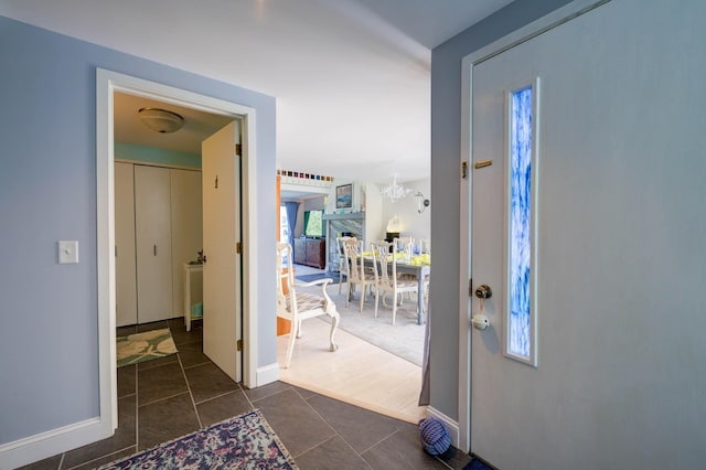 4 Goodridge Dr Unit 4, Naples, ME 04055 - foyer with dark tile patterned flooring, baseboards, and a chandelier