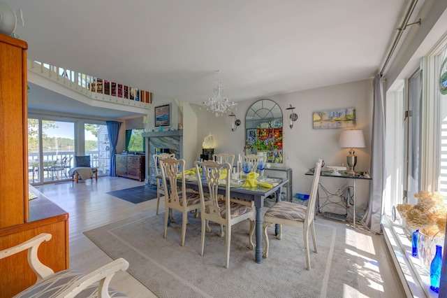 4 Goodridge Dr Unit 4, Naples, ME 04055 - dining space featuring a chandelier, a fireplace, wood finished floors, and a water view