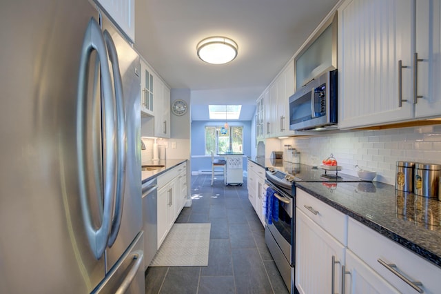 4 Goodridge Dr Unit 4, Naples, ME 04055 - kitchen with stainless steel appliances, a skylight, backsplash, glass insert cabinets, and white cabinets