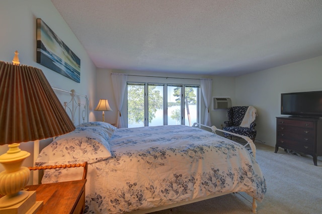 4 Goodridge Dr Unit 4, Naples, ME 04055 - bedroom featuring light colored carpet, a textured ceiling, and a wall unit AC