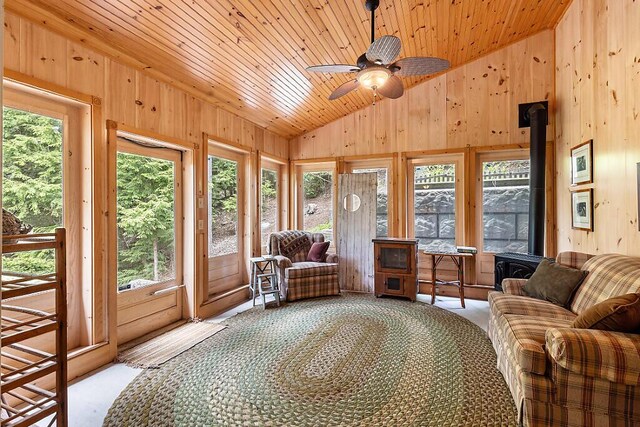 59 Lupine Dr, Belgrade, ME 04917 - sunroom with lofted ceiling, a wood stove, healthy amount of natural light, carpet flooring, and wood walls