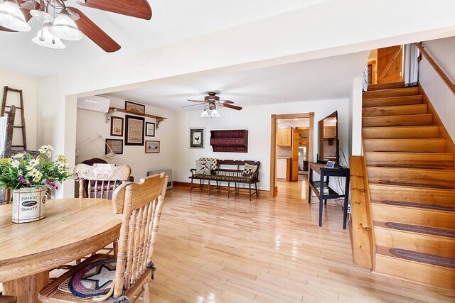 59 Lupine Dr, Belgrade, ME 04917 - dining area featuring ceiling fan, stairs, light wood-style flooring, an AC wall unit, and baseboards