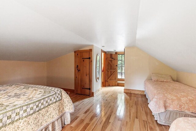 59 Lupine Dr, Belgrade, ME 04917 - bedroom featuring light wood-style floors, lofted ceiling, and baseboards
