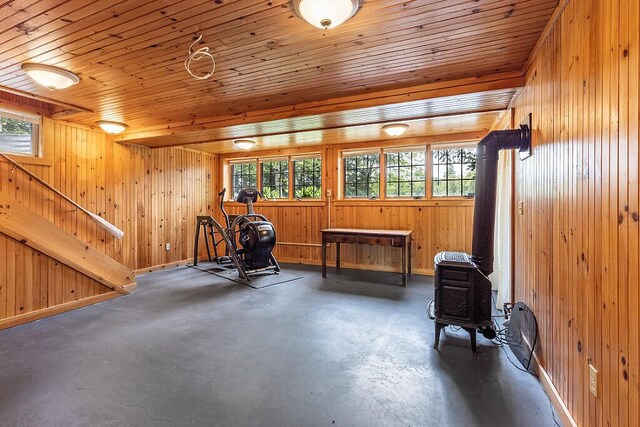 59 Lupine Dr, Belgrade, ME 04917 - living area featuring a wood stove, plenty of natural light, wood walls, concrete floors, and wood ceiling