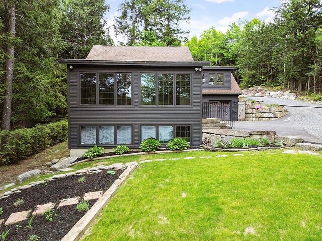 59 Lupine Dr, Belgrade, ME 04917 - view of front of house with a front lawn and a garage