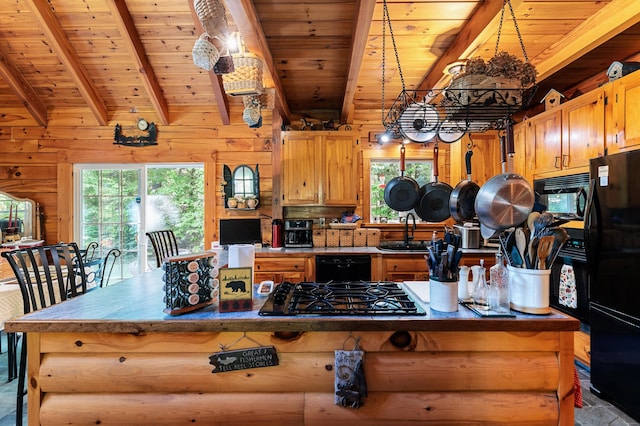 2451 Riverside Dr, Vassalboro, ME 04989 - kitchen featuring black appliances, a sink, wooden ceiling with exposed beams, wood walls, and a kitchen island