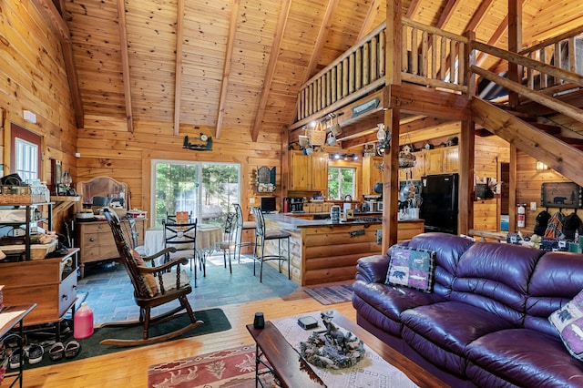 2451 Riverside Dr, Vassalboro, ME 04989 - living area with wooden walls, light wood finished floors, high vaulted ceiling, and wood ceiling with exposed beams