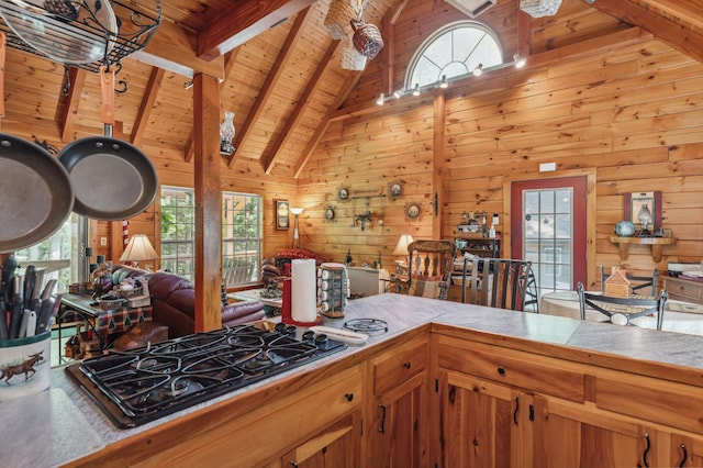 2451 Riverside Dr, Vassalboro, ME 04989 - kitchen featuring black gas cooktop, open floor plan, wood ceiling with exposed beams, wooden walls, and high vaulted ceiling