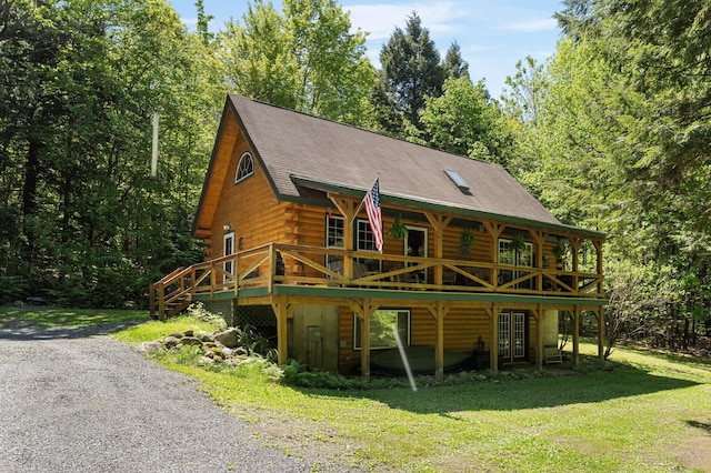 2451 Riverside Dr, Vassalboro, ME 04989 - log cabin with log siding, a front yard, a wooden deck, a shingled roof, and driveway