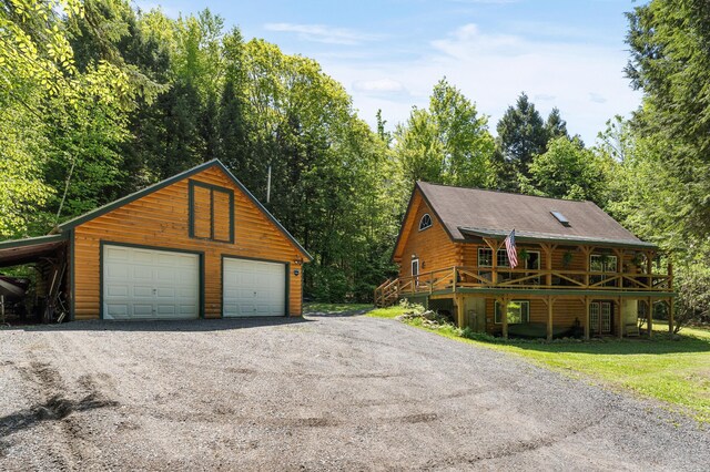 2451 Riverside Dr, Vassalboro, ME 04989 - view of front of property featuring a detached garage, an outbuilding, log exterior, and a deck