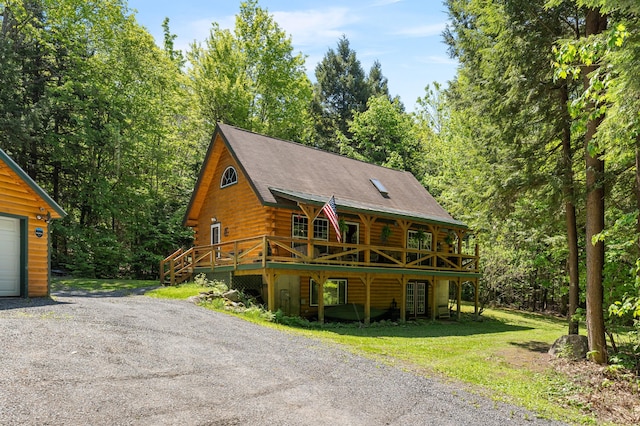 2451 Riverside Dr, Vassalboro, ME 04989 - log-style house with log exterior, a wooden deck, and a view of trees