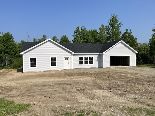 93 Union St, Orono, ME 04473 - view of front facade featuring a garage, roof with shingles, and dirt driveway