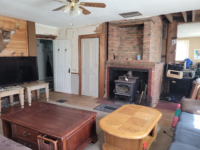 627 Waterville Rd, Skowhegan, ME 04976 - living room featuring a wood stove, ceiling fan, and wood finished floors