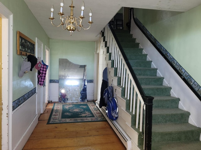 627 Waterville Rd, Skowhegan, ME 04976 - foyer featuring wood finished floors, stairway, a chandelier, and a baseboard radiator
