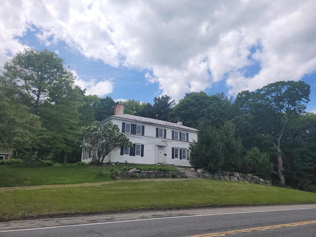 627 Waterville Rd, Skowhegan, ME 04976 - colonial home with a chimney, a front lawn, and metal roof
