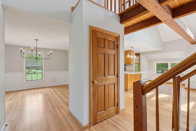 198 Range Rd, Cumberland, ME 04021 - corridor with a chandelier, light wood finished floors, a wainscoted wall, a baseboard radiator, and baseboards