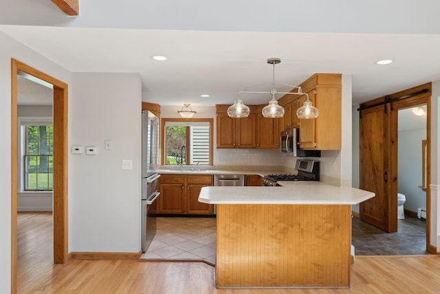 198 Range Rd, Cumberland, ME 04021 - kitchen with stainless steel appliances, light countertops, a barn door, a peninsula, and recessed lighting