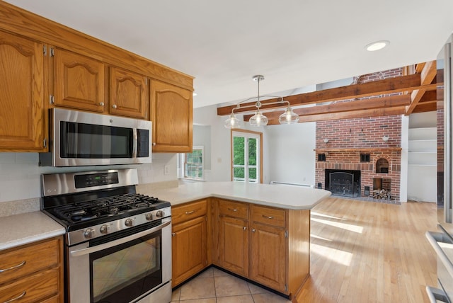 198 Range Rd, Cumberland, ME 04021 - kitchen with stainless steel appliances, light countertops, a peninsula, brown cabinetry, and open floor plan