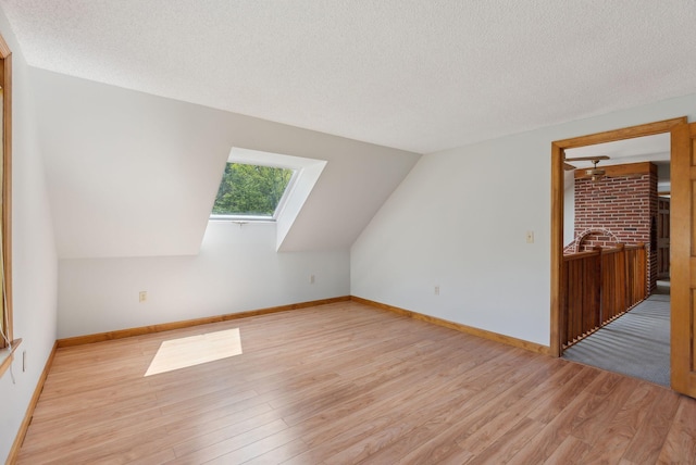 198 Range Rd, Cumberland, ME 04021 - bonus room with a skylight, light wood-style flooring, a textured ceiling, baseboards, and lofted ceiling