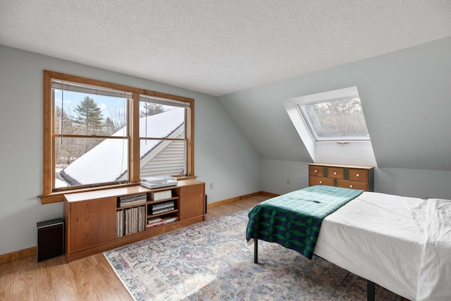 198 Range Rd, Cumberland, ME 04021 - bedroom with light wood-style flooring, a skylight, lofted ceiling, baseboards, and a textured ceiling