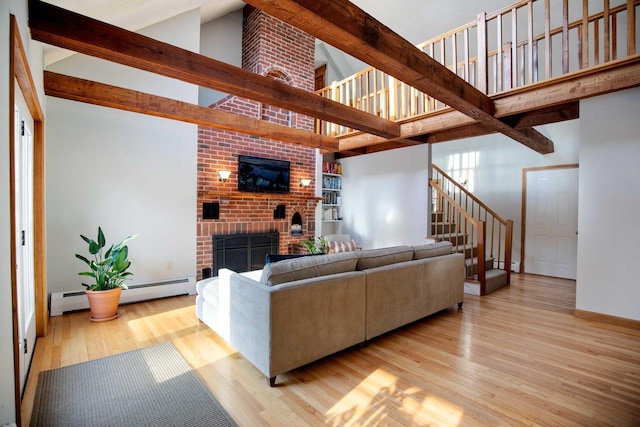 198 Range Rd, Cumberland, ME 04021 - living room with high vaulted ceiling, a brick fireplace, light wood-style floors, beam ceiling, and stairs