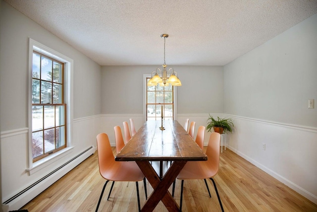 198 Range Rd, Cumberland, ME 04021 - dining room featuring baseboard heating, light wood-type flooring, a chandelier, plenty of natural light, and a textured ceiling