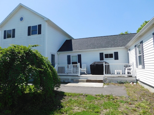 56 Allen St, Bangor, ME 04401 - rear view of house with a wooden deck, a patio area, and roof with shingles