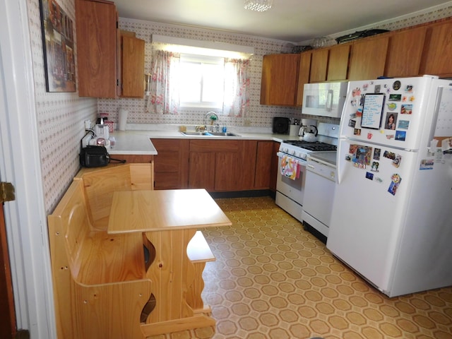 56 Allen St, Bangor, ME 04401 - kitchen featuring white appliances, wallpapered walls, a sink, light countertops, and brown cabinetry