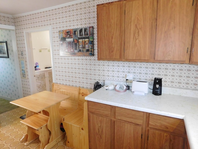 56 Allen St, Bangor, ME 04401 - kitchen featuring wallpapered walls, light countertops, crown molding, and brown cabinetry