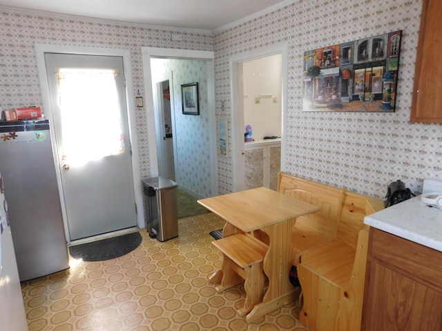 56 Allen St, Bangor, ME 04401 - kitchen featuring ornamental molding, freestanding refrigerator, wallpapered walls, light countertops, and breakfast area