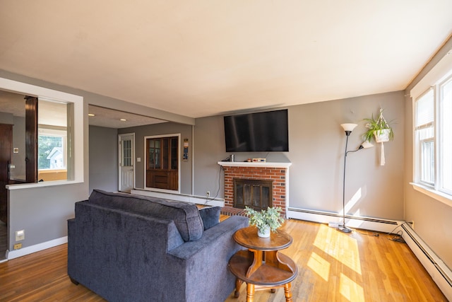 4 Scribner Cir, Lewiston, ME 04240 - living area featuring wood finished floors, a brick fireplace, and a baseboard radiator