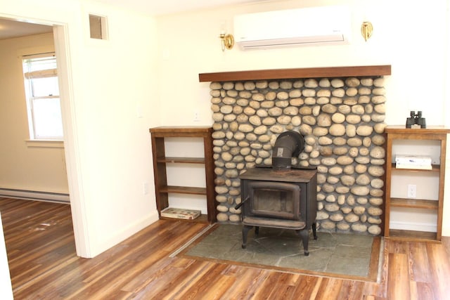 35 Harmon Notch Rd, Brownfield, ME 04010 - detailed view of an AC wall unit, a baseboard radiator, a wood stove, and wood finished floors