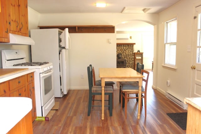 35 Harmon Notch Rd, Brownfield, ME 04010 - kitchen featuring white gas range, baseboard heating, under cabinet range hood, wood finished floors, and arched walkways