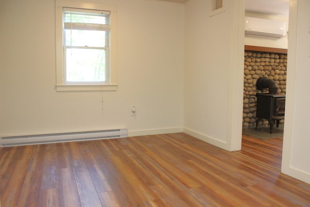 35 Harmon Notch Rd, Brownfield, ME 04010 - empty room with a wall unit AC, wood finished floors, baseboard heating, and baseboards